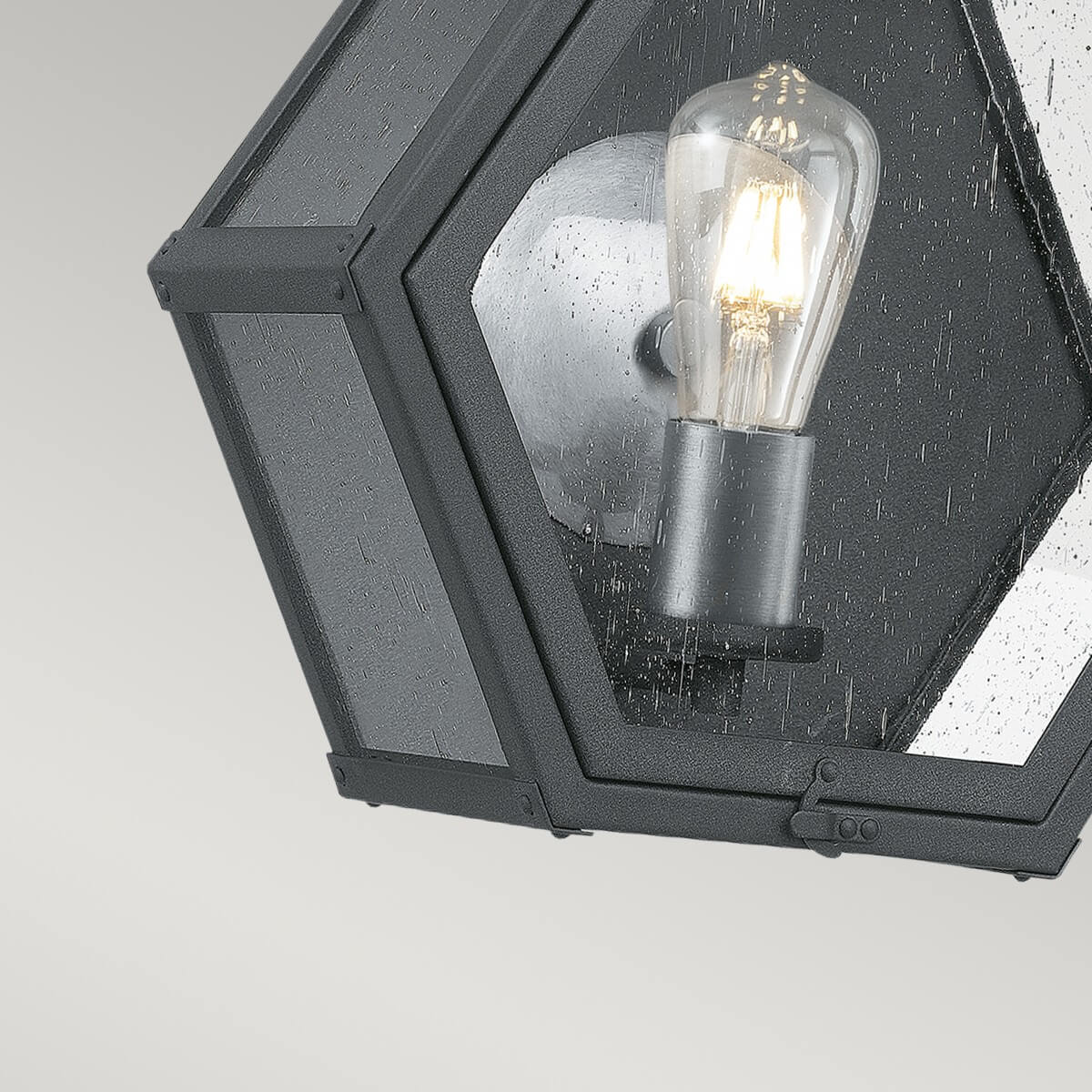 Gros plan de l'ampoule à filament, douille et fixation métallique sur verre moucheté