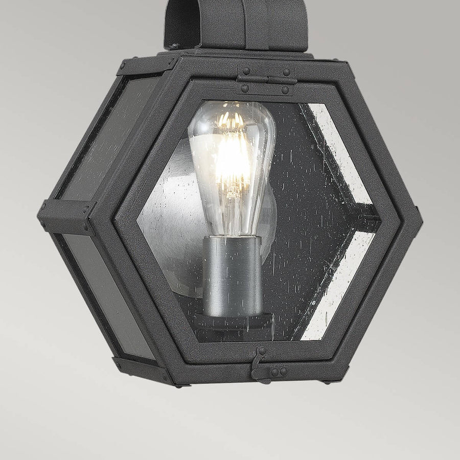 Gros plan sur la façade hexagonale, ampoule Edison et verre transparent moucheté