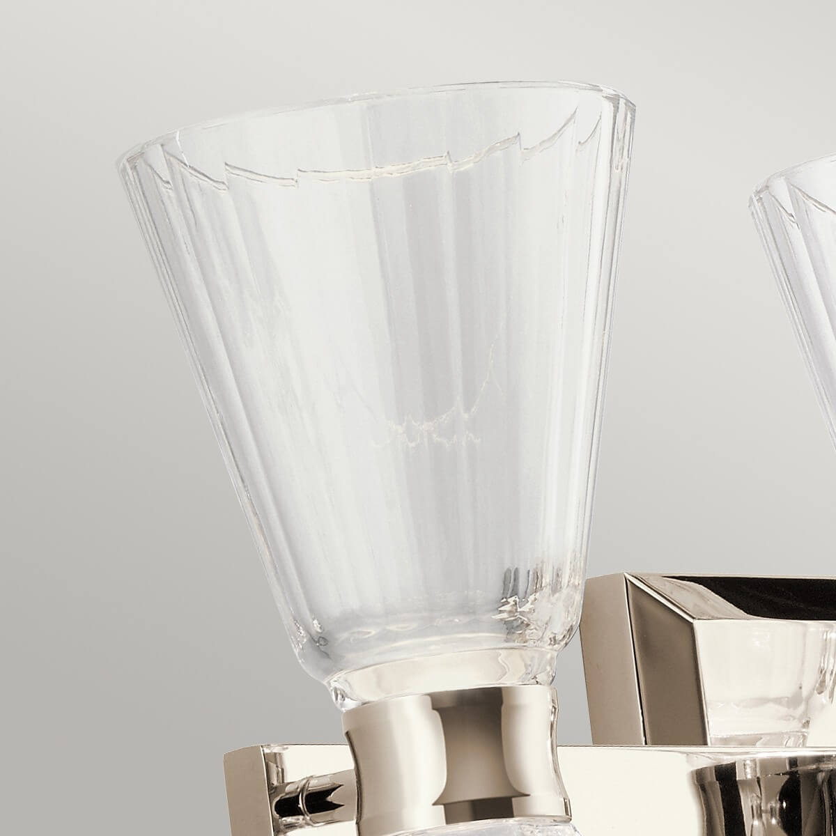 Détail d'un verre transparent au bord festonné posé sur sa douille
