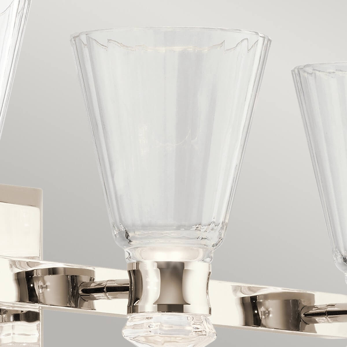 Verre transparent au bord ondulé monté sur une applique en nickel poli.