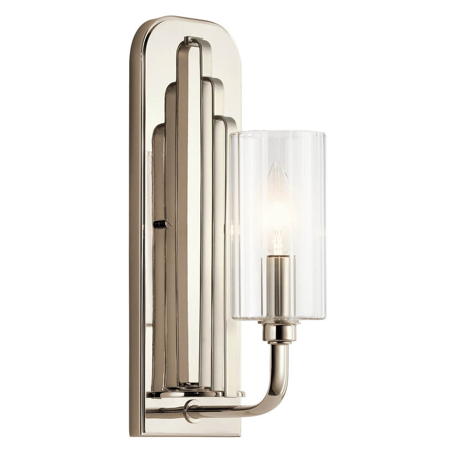 Applique murale en nickel poli avec bras recourbé et cylindre en verre transparent allumé.