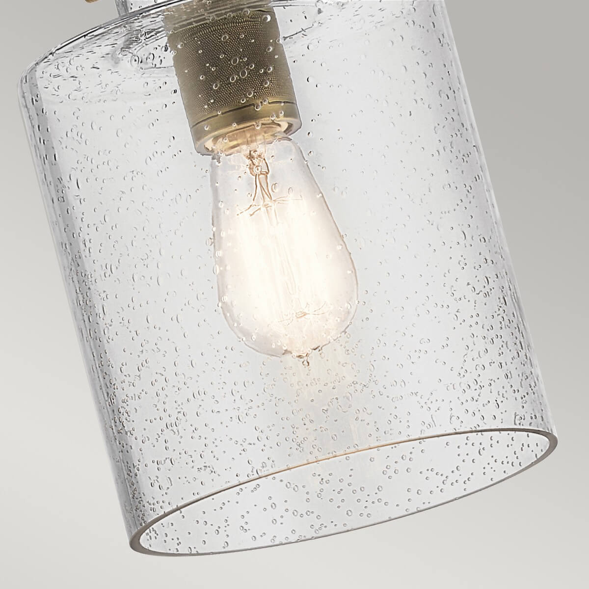 Détail de l'ampoule allumée à l'intérieur du cylindre en verre grenu