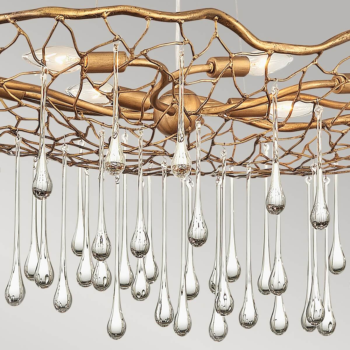 Détail des ampoules allumées sous le treillage doré et des pendants transparents