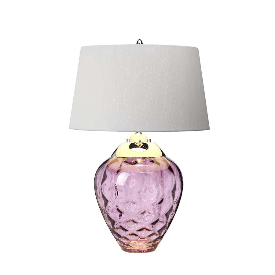 Même lampe vue de face, finition laiton doré et verre rose transparent aux reflets lumineux