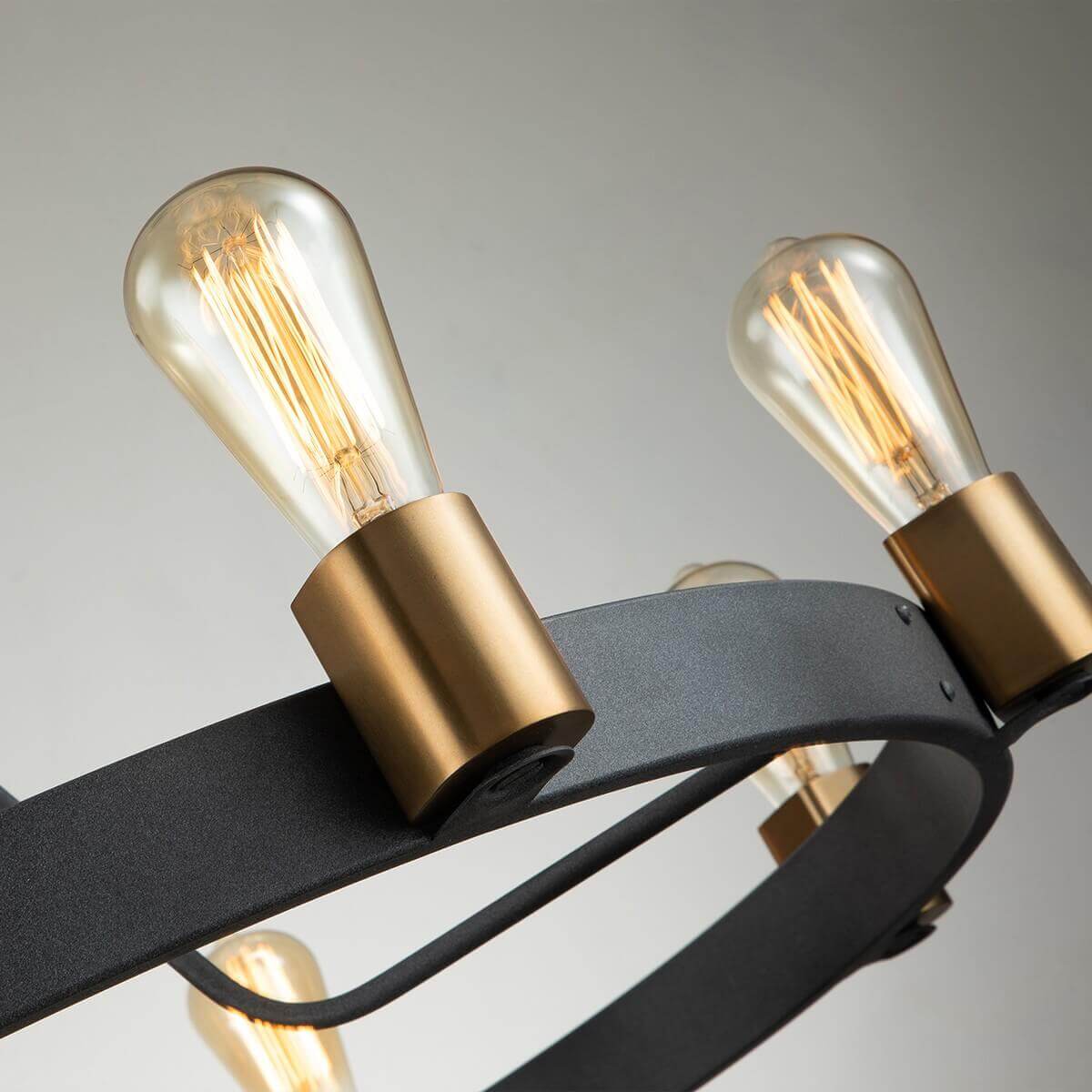 Gros plan sur deux supports de douille dorés fixés à la structure circulaire en métal noir.