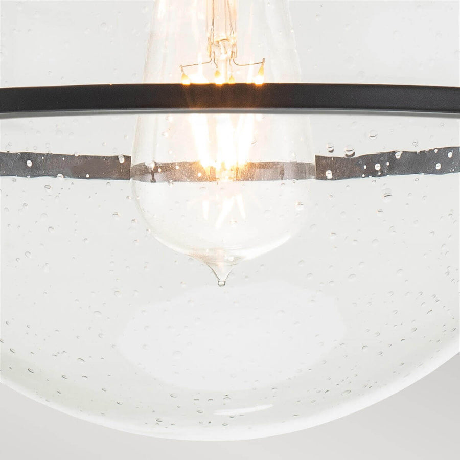Gros plan sur l'ampoule à filament allumée au centre du globe transparent