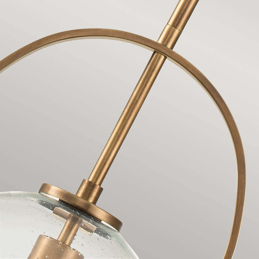 Détail de l'arceau métallique doré croisant la tige sur la sphère de verre