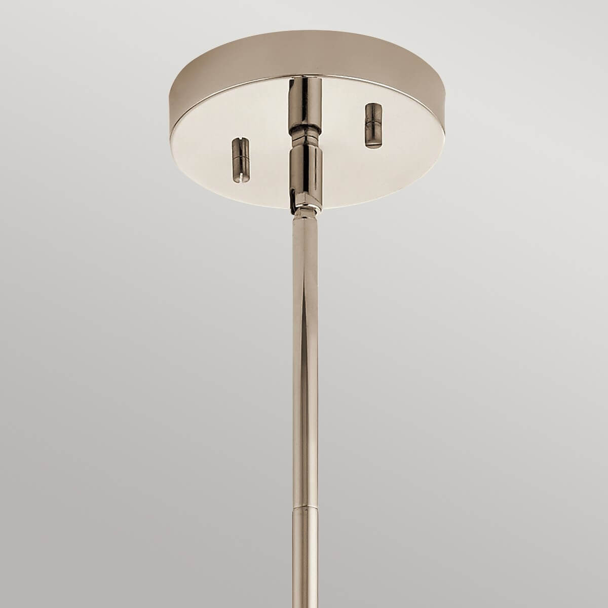 Détail du pavillon rond en nickel et de la tige verticale fixée au plafond.