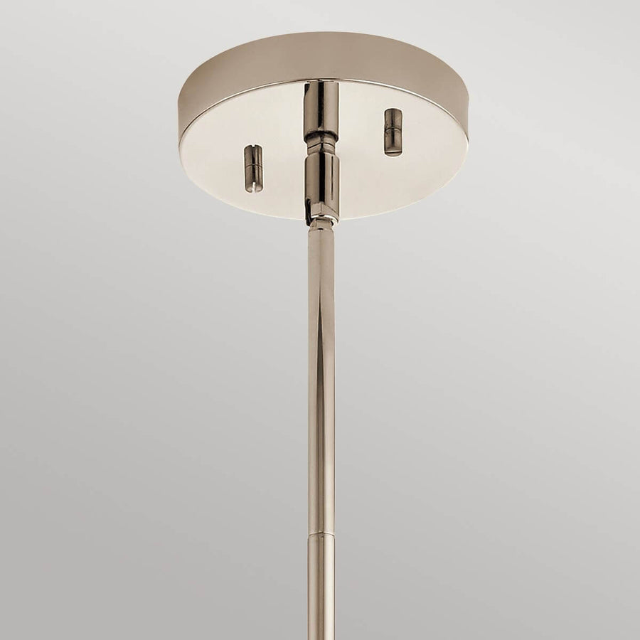Détail du pavillon rond en nickel et de la tige verticale fixée au plafond.