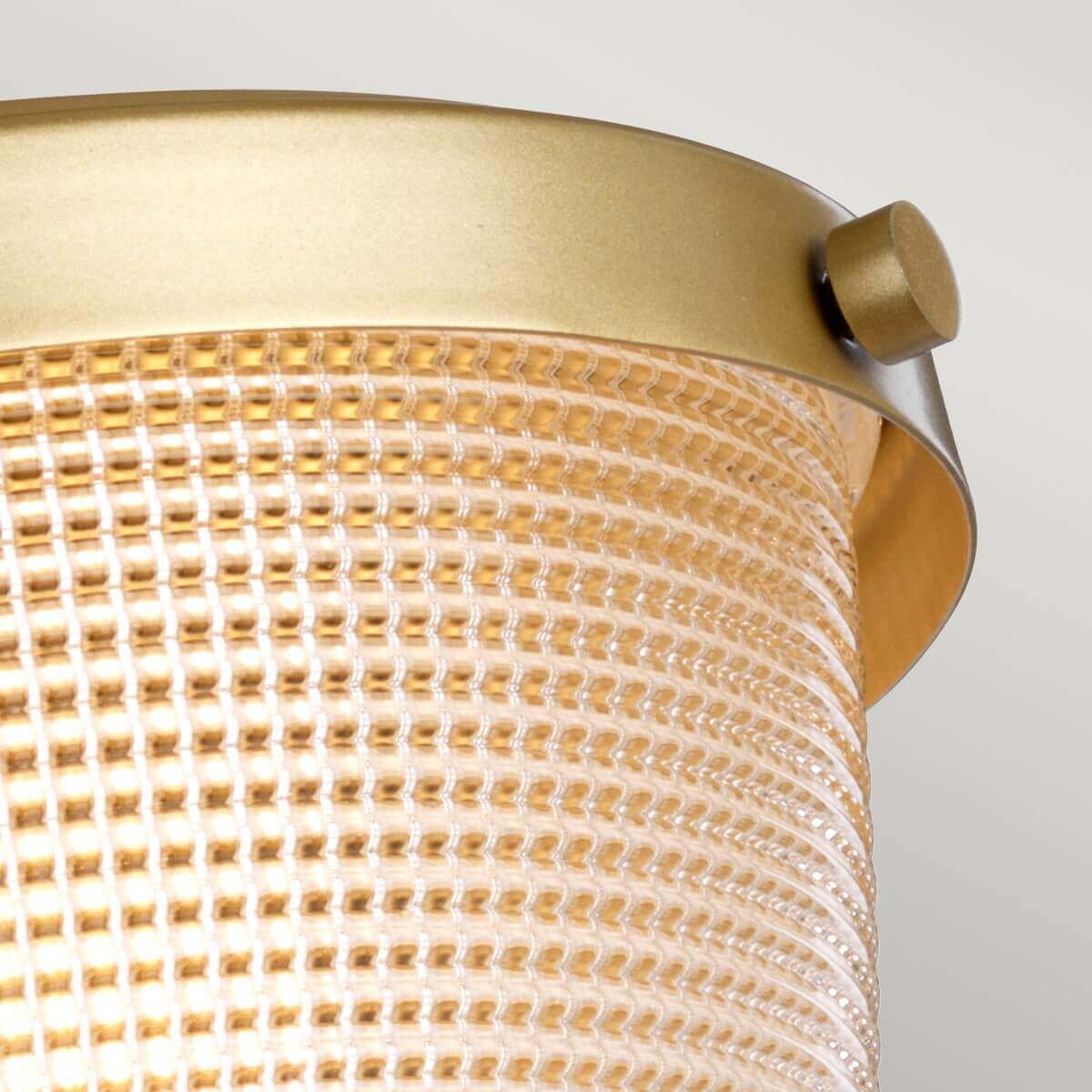 Détail du verre prismatique maintenu par une vis dorée sur le bandeau