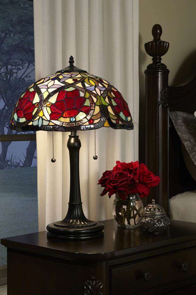 Mise en ambiance de la lampe sur une table de chevet, avec des roses rouges