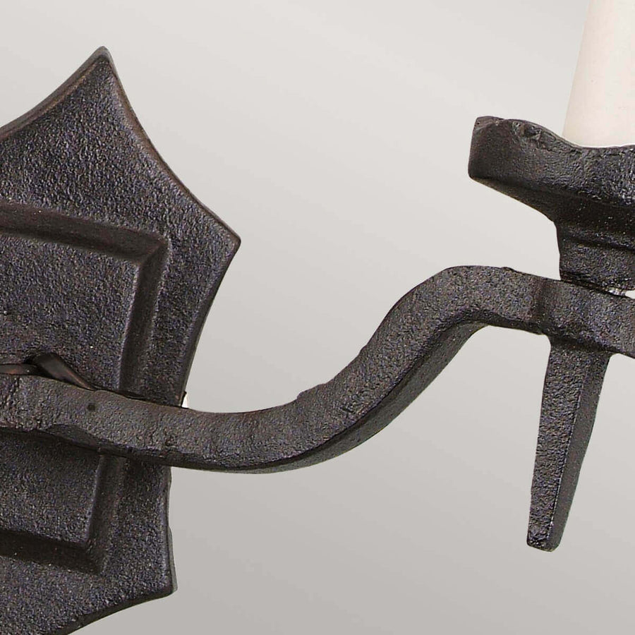 Détail de profil d'un bras cintré en fonte noire et sa douille