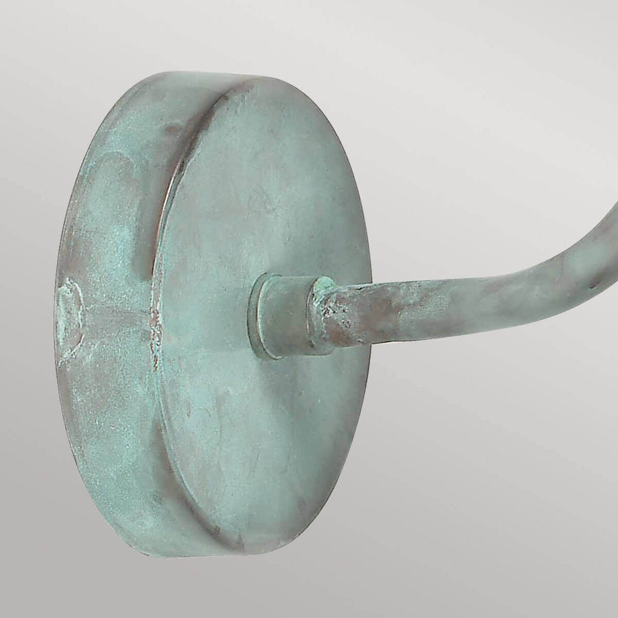 Détail de la platine ronde de fixation au mur en métal vert-de-gris