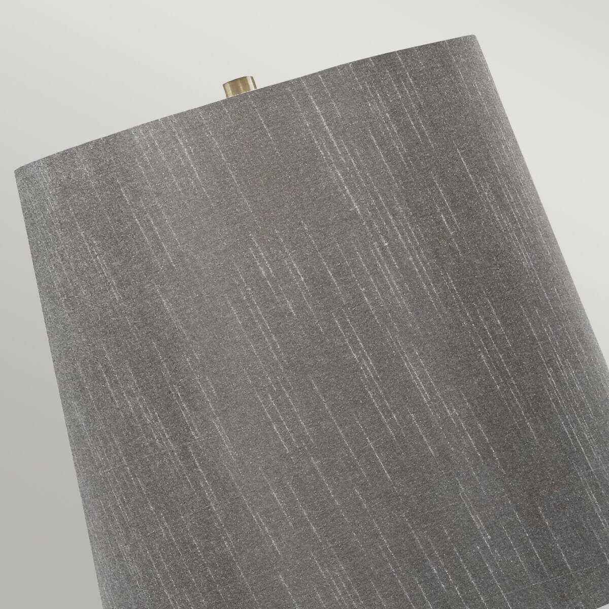 Détail de l'abat-jour en tissu gris texturé avec finition en laiton