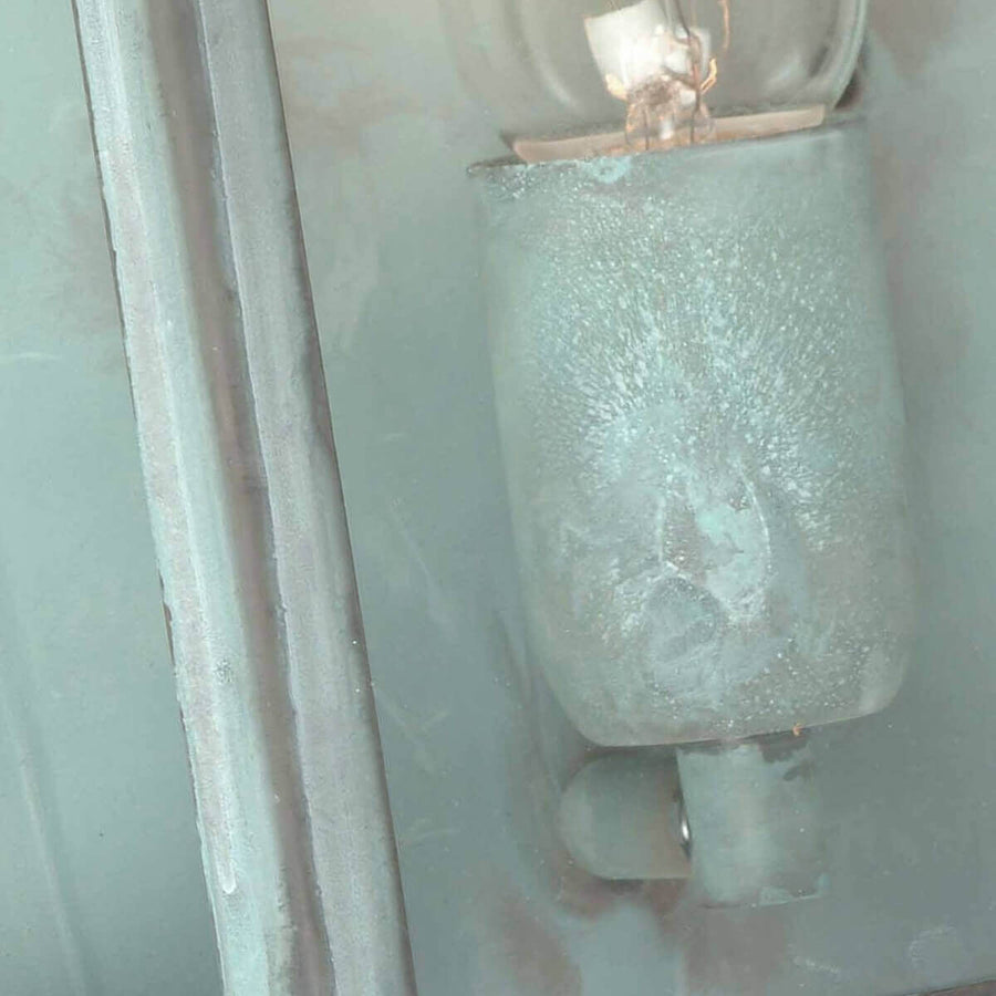 Gros plan de la douille et de l'ampoule, traces de patine vert-de-gris