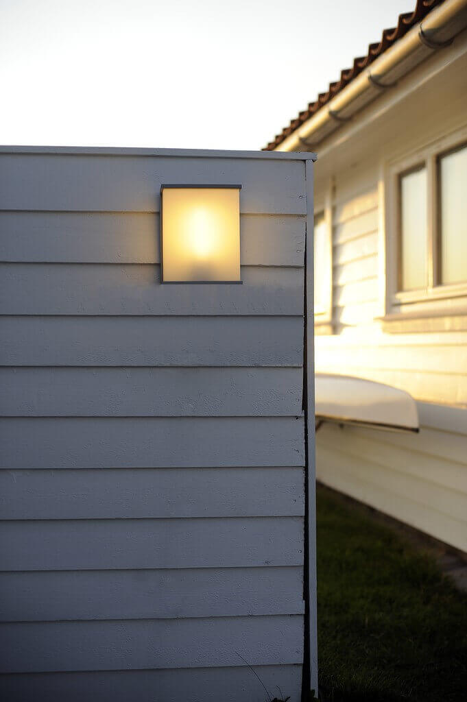 Mise en ambiance sur une façade de bardage blanc, lumière chaude allumée