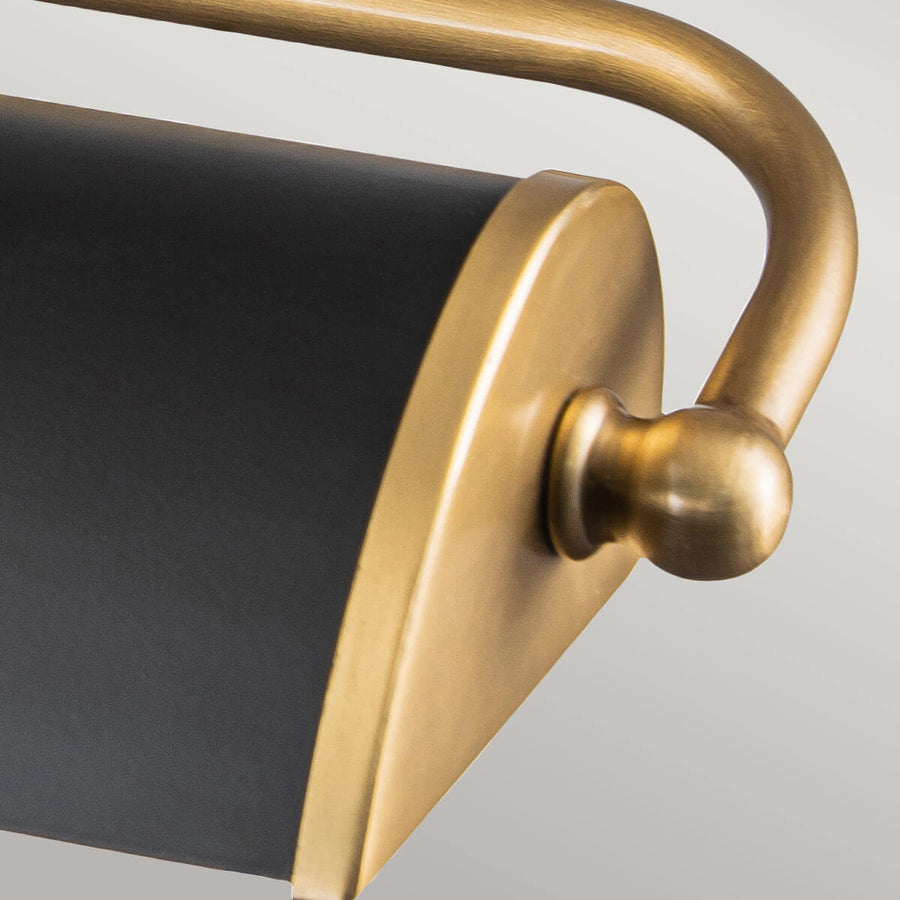 Extrémité arrondie de l'abat-jour noir avec bouton sphérique doré