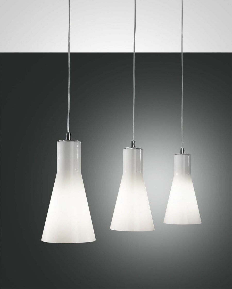 Trois suspensions coniques en verre opalin blanc, fixations et câbles chromés, fond gris dégradé.