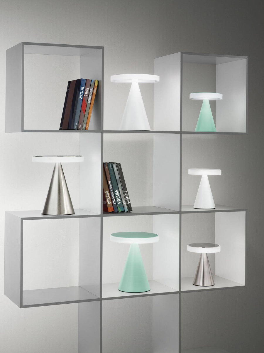 Étagère blanche avec plusieurs lampes colorées, livres et divers modèles exposés.