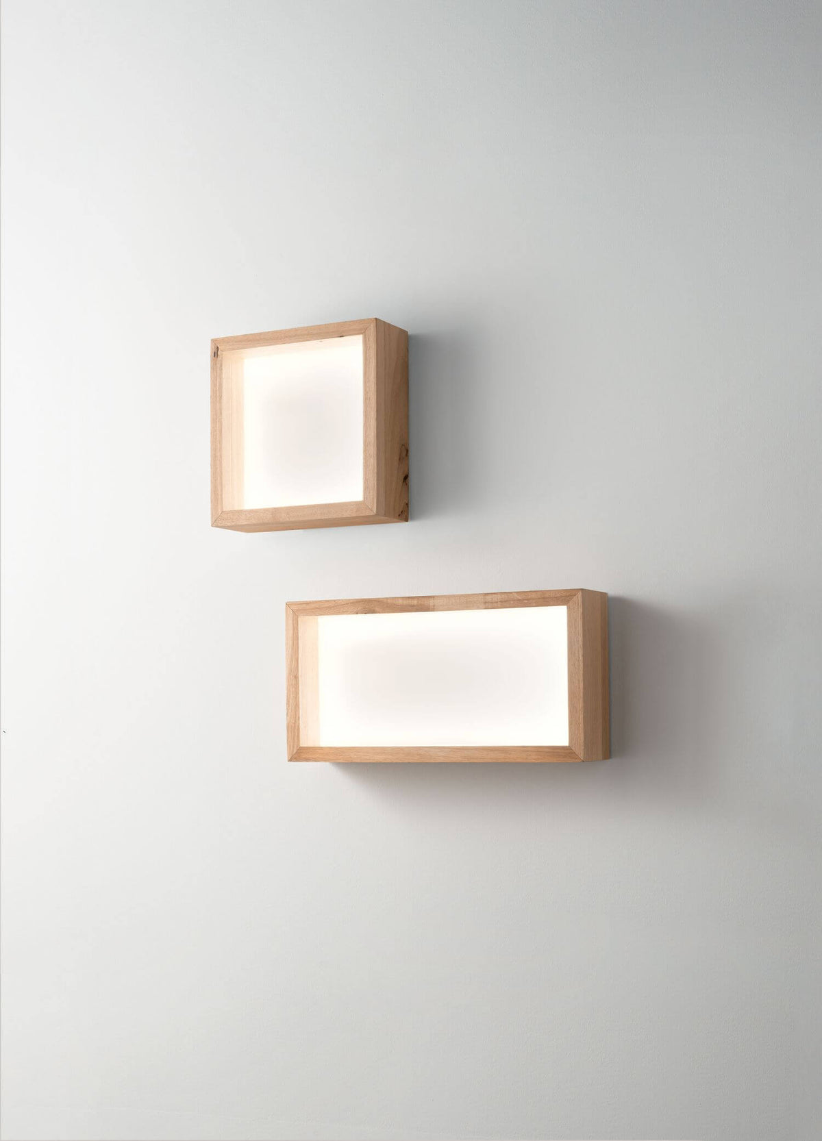 Deux appliques murales en bois, format carré et rectangulaire, sur mur blanc