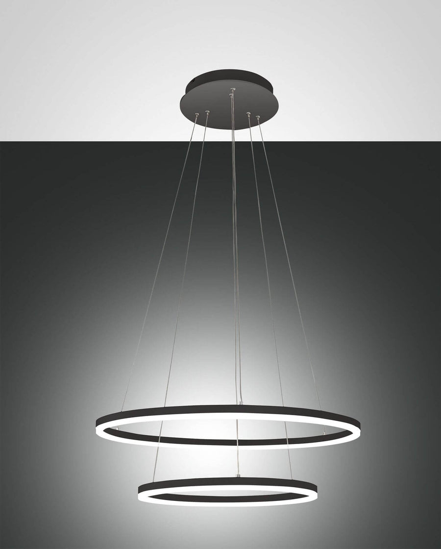 Suspension noire à deux anneaux LED superposés, vue de face sur fond gris dégradé