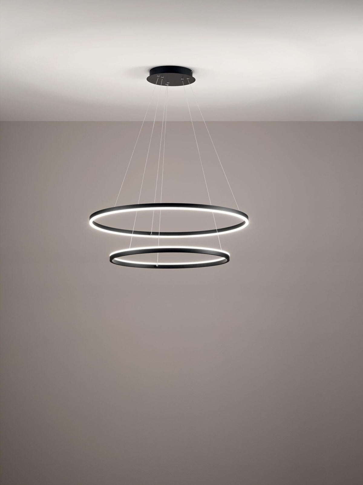 Luminaire annulaire double suspendu au plafond dans une pièce aux murs beiges