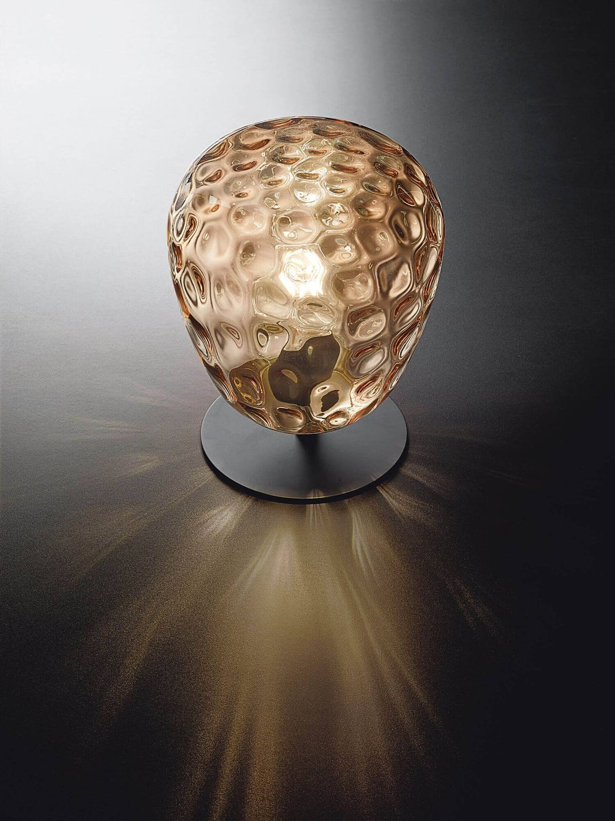 Vue de face du globe ambré diffusant une lumière dorée sur fond sombre