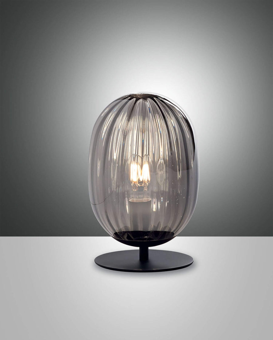 Lampe à poser de face, abat-jour en verre fumé nervuré sur socle noir rond