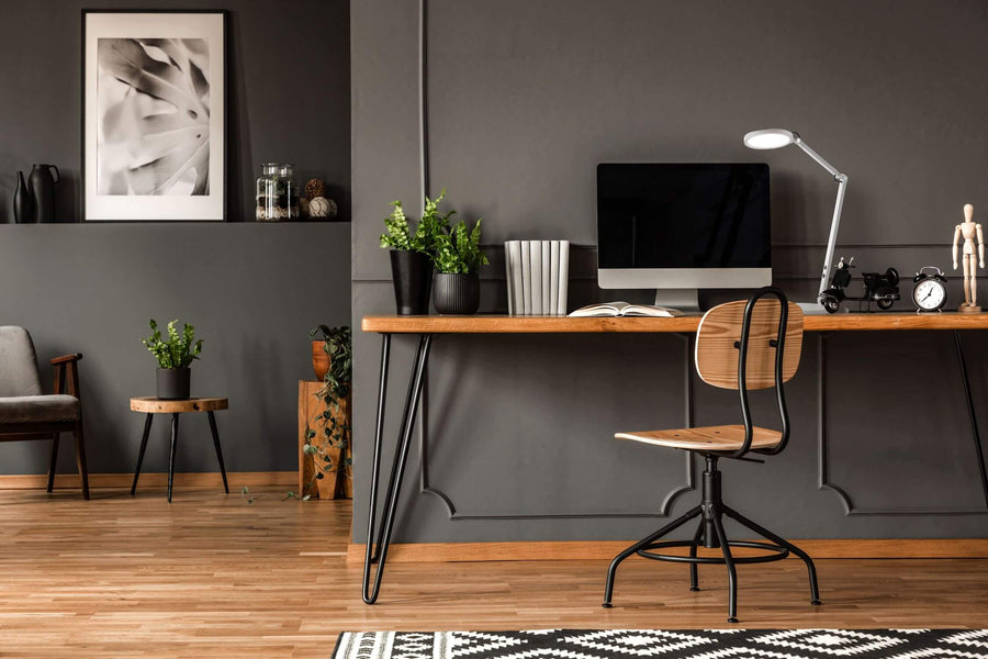 Lampe blanche installée sur un bureau en bois dans un intérieur gris contemporain
