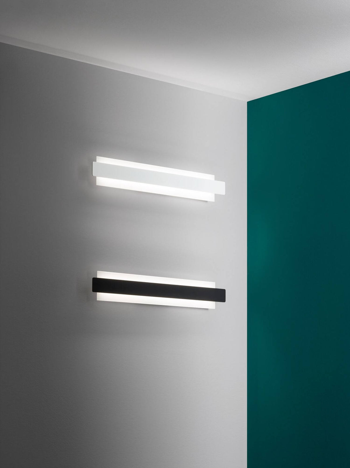 Mise en situation de deux appliques murales allumées, mur blanc et panneau vert