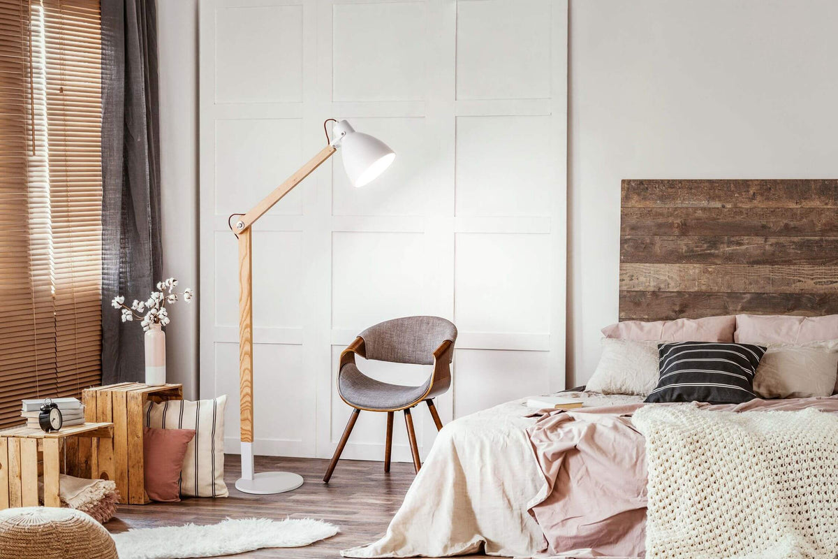 Mise en ambiance dans une chambre, lampe allumée près du lit et fauteuil