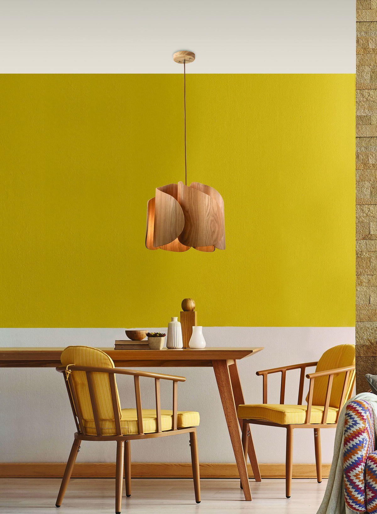 Mise en ambiance au-dessus d'une table de salle à manger, mur jaune et chaises bois