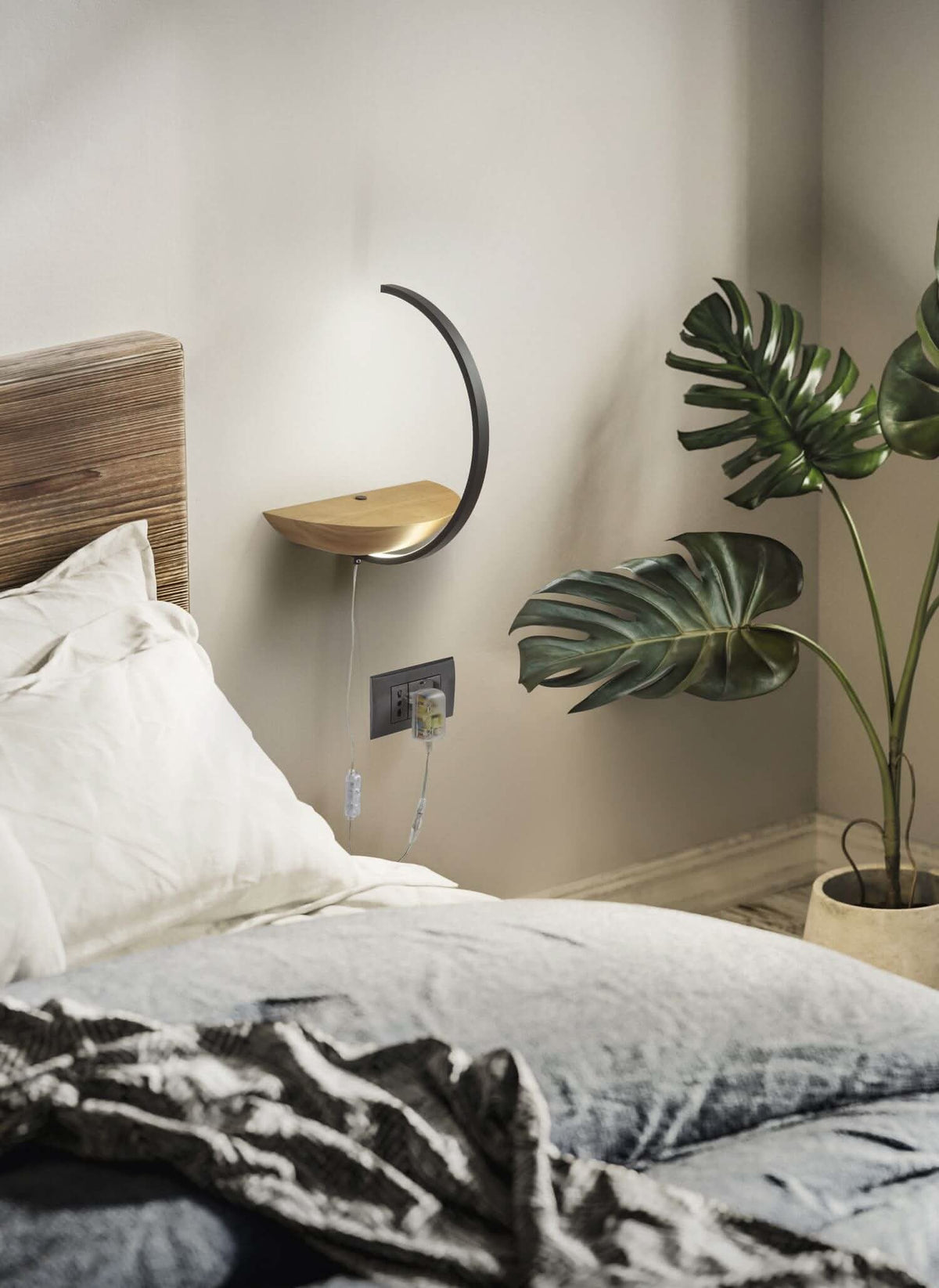Mise en ambiance dans une chambre, au-dessus d'un lit avec plante verte