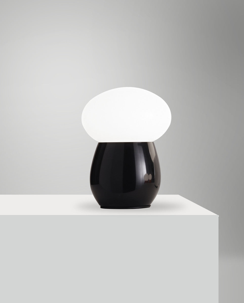 Lampe présentée sur un socle blanc, éclairage allumé, fond gris clair uni