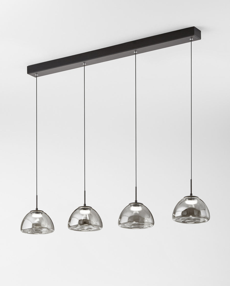 Suspension à quatre cloches de verre fumé alignées sur un rail noir