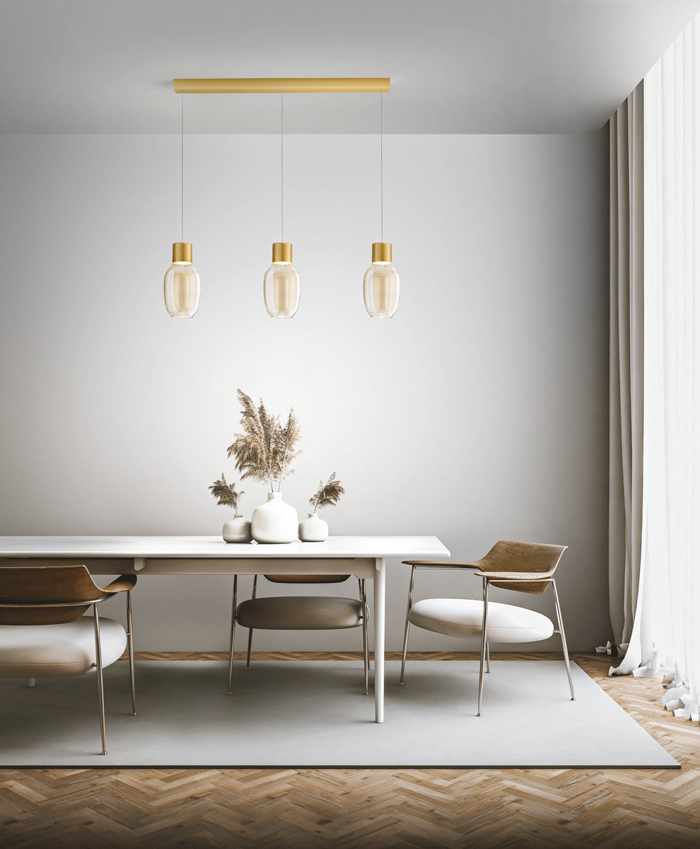 Suspension dorée à trois verres installée au-dessus d'une table de salle à manger.