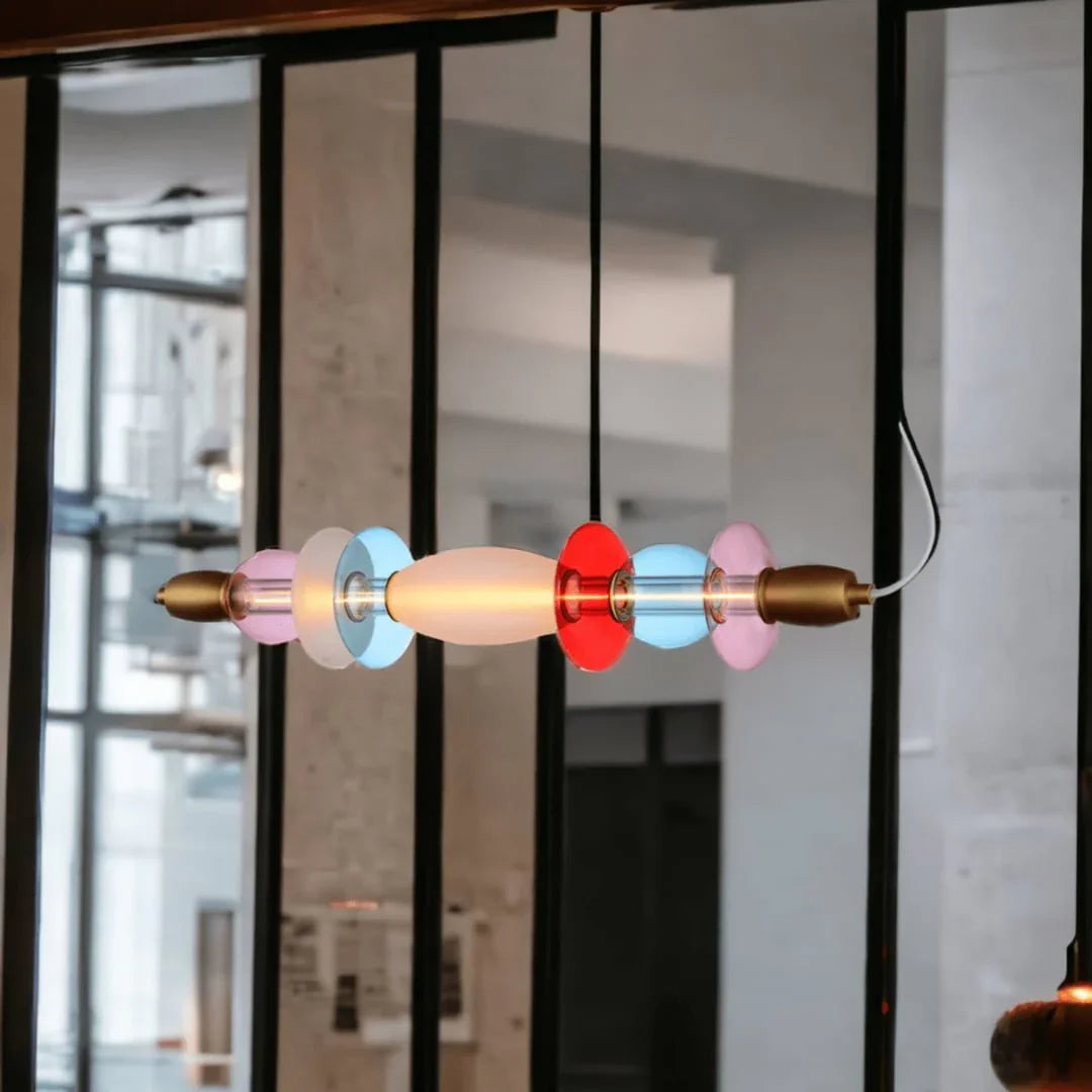 Gros plan de la suspension colorée en verre soufflé devant une fenêtre d'atelier