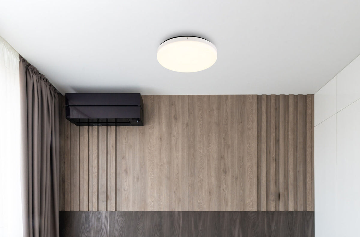 Mise en ambiance : plafonnier fixé au plafond d'un séjour au mur bois
