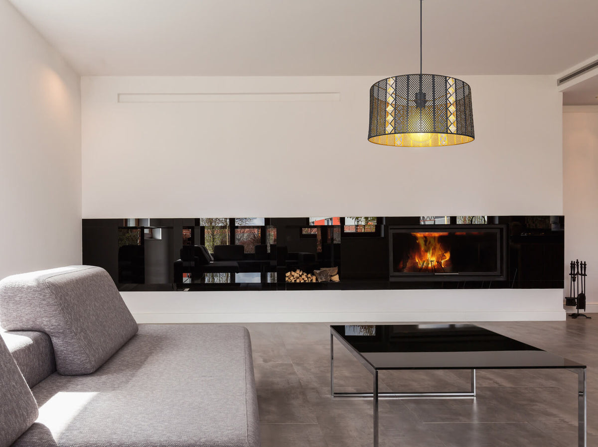 Mise en ambiance dans un salon moderne, suspension allumée au-dessus d'une table basse