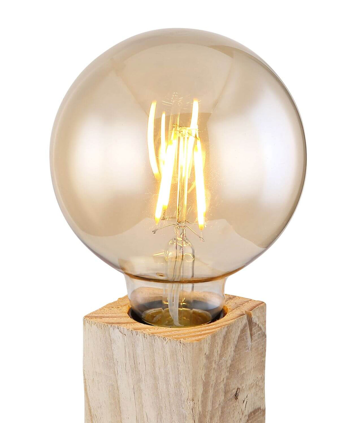 Gros plan sur l'ampoule globe ambrée et ses filaments lumineux posée sur le bois