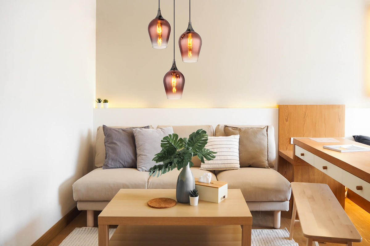 Mise en ambiance dans un salon, suspension allumée au-dessus d'un canapé beige.