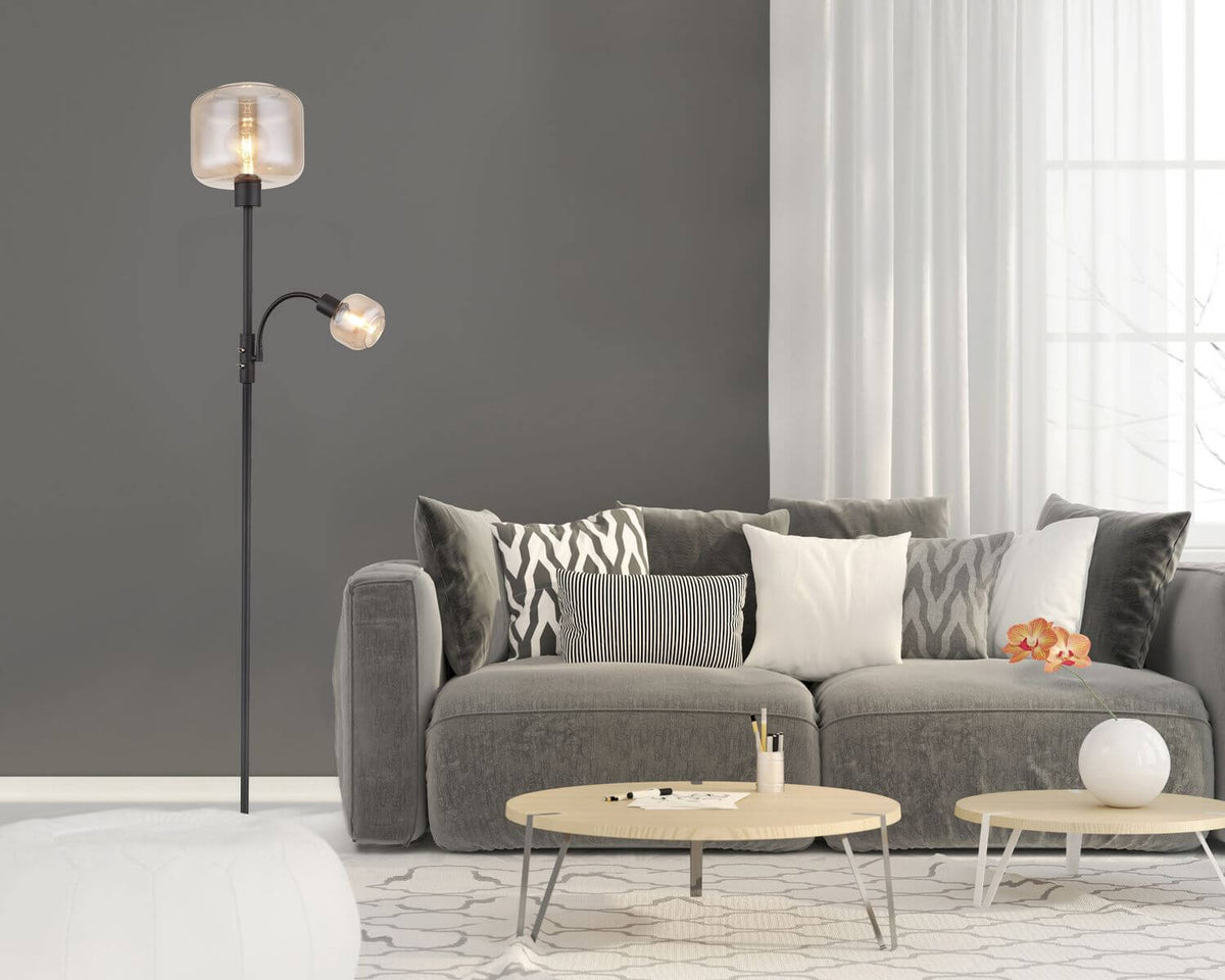 Mise en ambiance dans un salon gris avec canapé, coussins et tables basses
