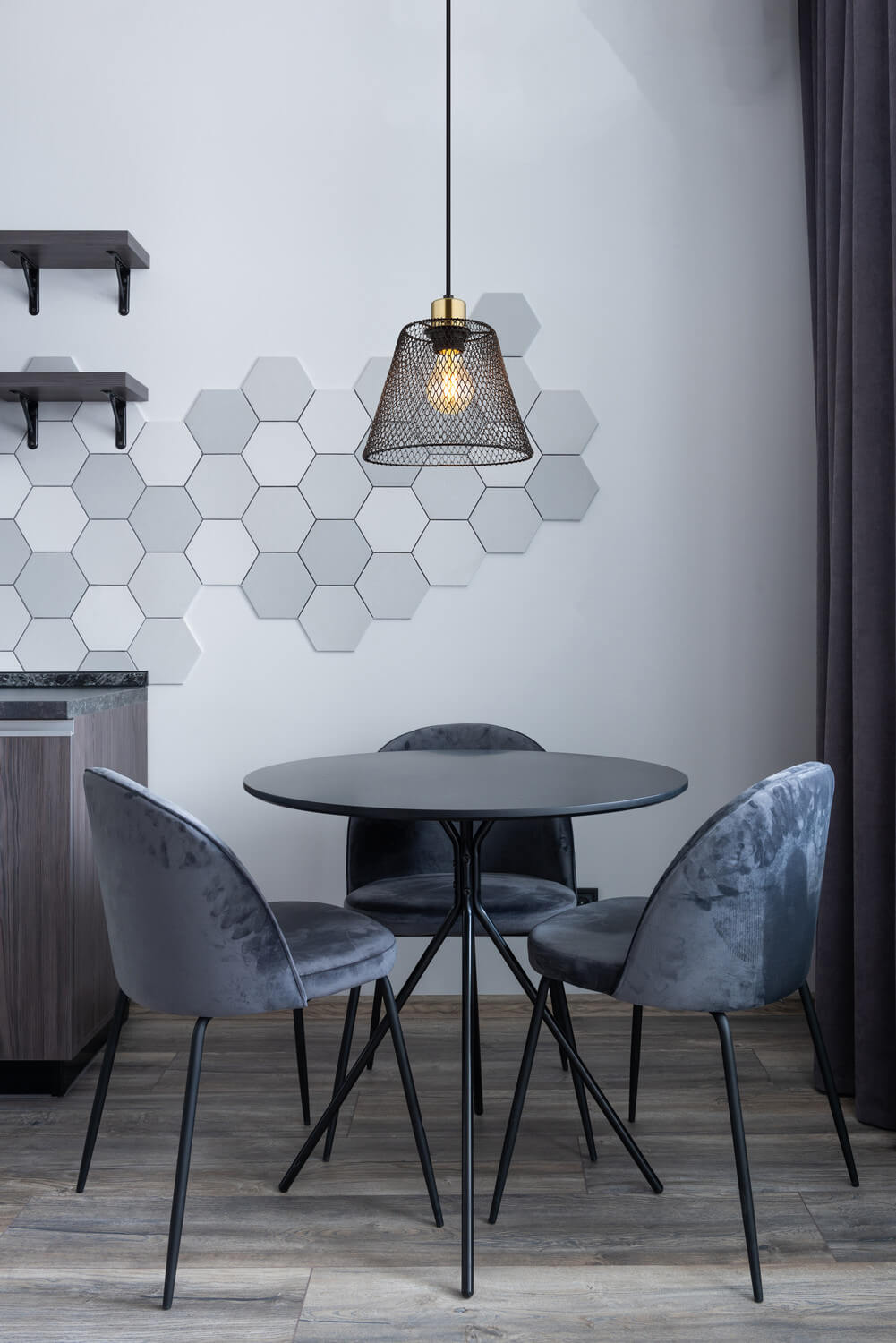 Mise en ambiance au-dessus d’une table ronde dans un intérieur contemporain aux murs hexagonaux.