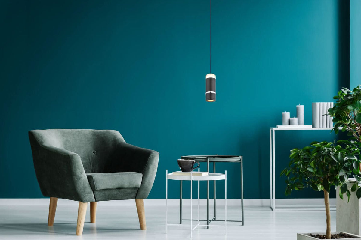 Mise en ambiance du salon avec la suspension noire au-dessus d'une table basse blanche.