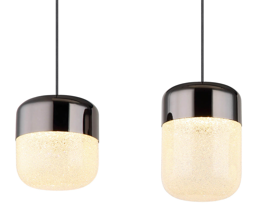Détail rapproché de deux diffuseurs allumés, verre texturé et capuchon métallique brillant