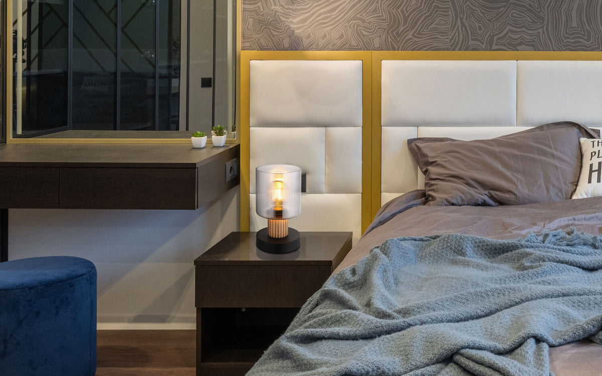 Lampe posée sur une table de nuit dans une chambre, ambiance chaleureuse