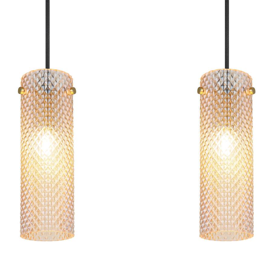 Gros plan sur deux suspensions cylindriques en verre diamanté, finition dorée et lumière chaude.
