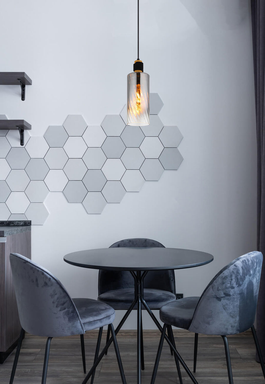 Vue rapprochée en situation : luminaire suspendu au-dessus d'une table, ampoule chaude et verre texturé.