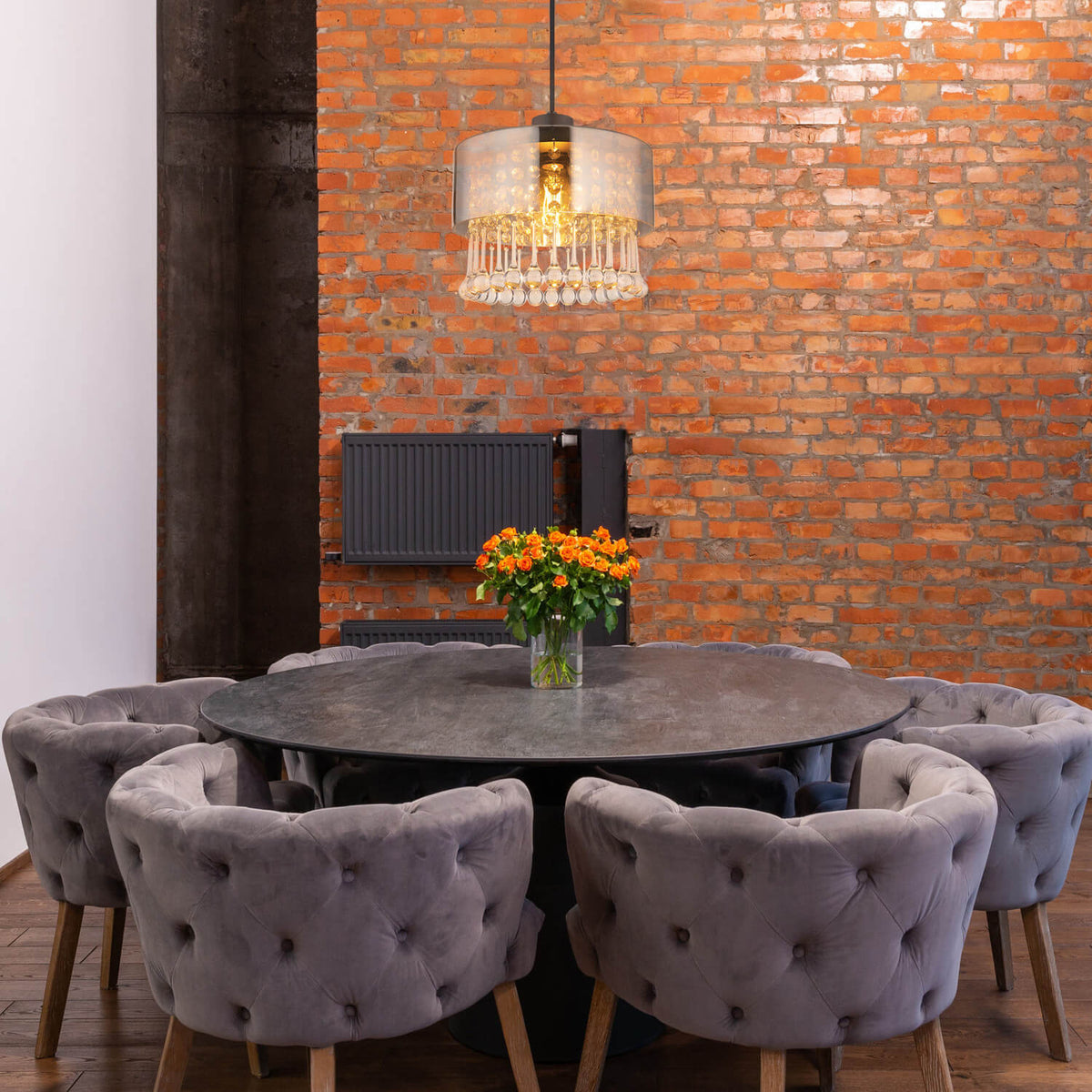 Mise en ambiance au-dessus d'une table ronde dans un intérieur brique et velours gris