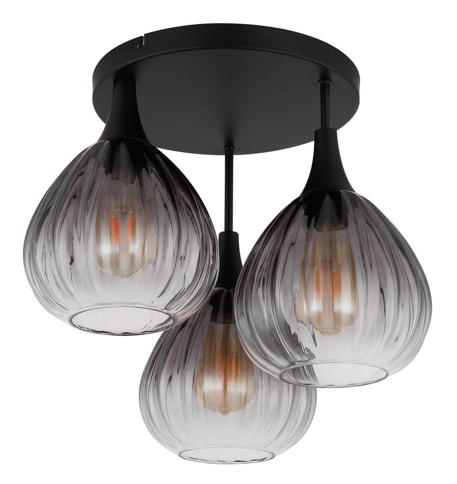 Détail des trois globes en verre nervuré transparent, ampoules éteintes, sur fond blanc neutre